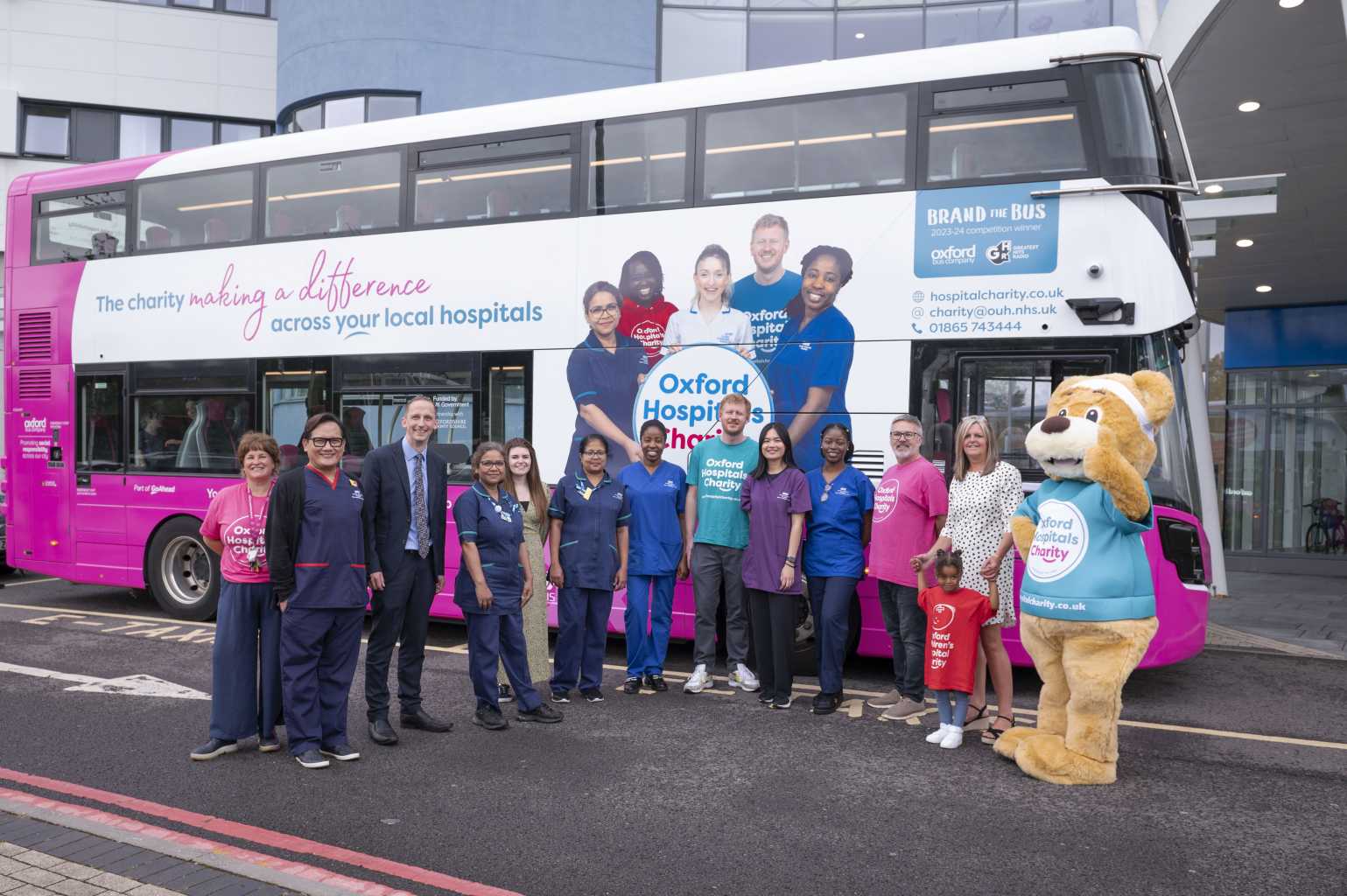 Oxford Bus Company bus featuring Oxford Hospitals Charity wrap outside the John Radcliffe Hospital. Members of the charity are standing in front of the bus with Luke Marion, CEO of the Oxford Bus Company.